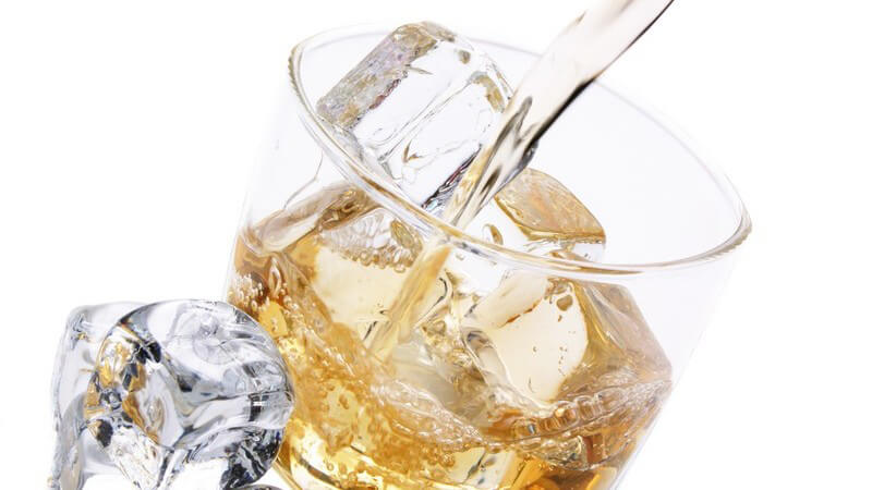 Nahaufnahme alkoholisches Getränk wird in Glas mit Eiswürfeln geschüttet