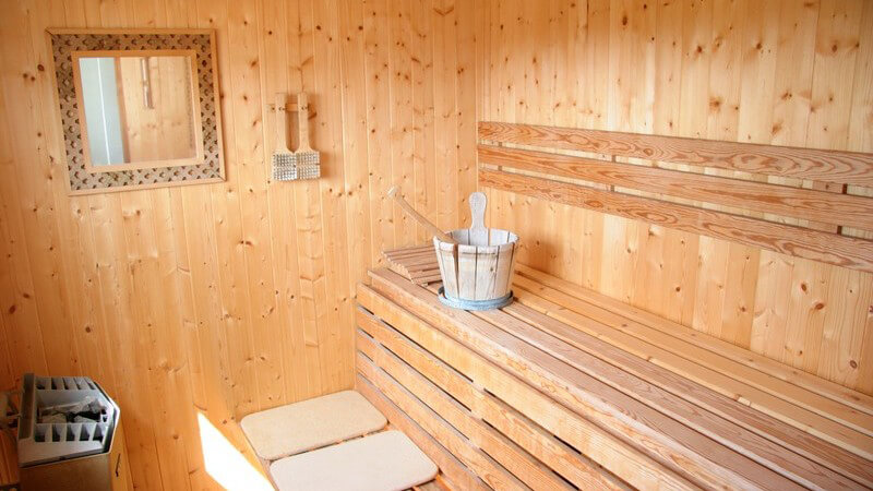 Einblick in Sauna mit Holzbänken und Sitzkissen