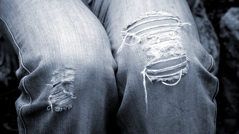 Beine in teils zerrissener Jeans