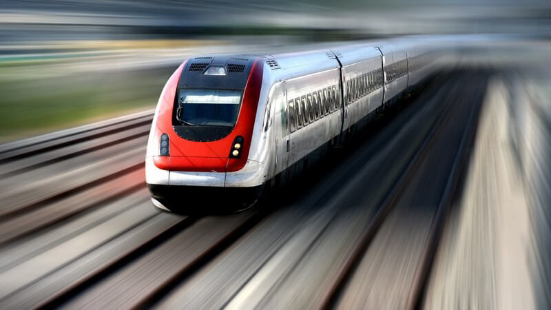 Zug ICE, der mit hoher Geschwindigkeit auf Gleisen fährt, Umgebung unscharf