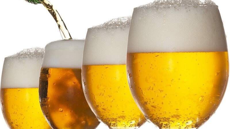Bier wird aus Flasche in Gläser geschüttet, weißer Hintergrund