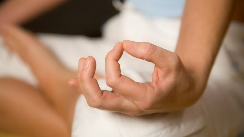 Nahaufnahme auf Knie aufgestützte Hand, Yogaübung