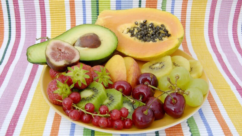 Teller mit verschiedenen Sorten Obst und Avocado