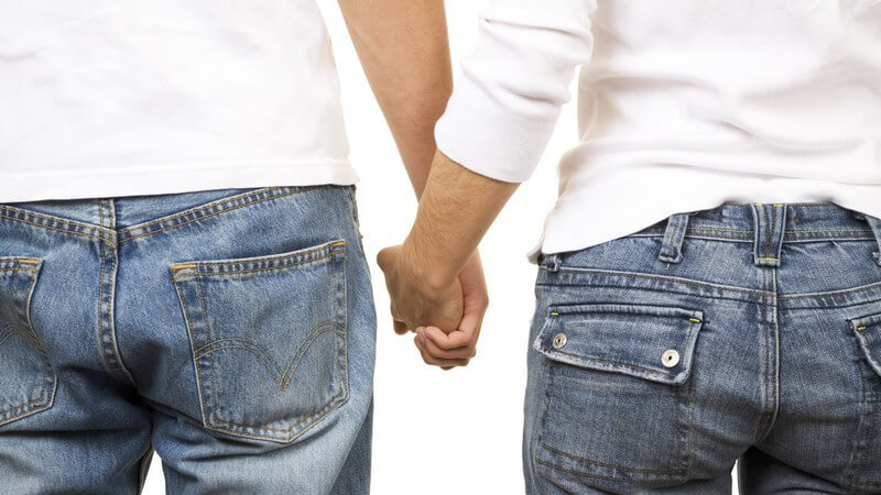 Rückansicht junges Hand haltendes Paar in Blue Jeans und weißem Shirt