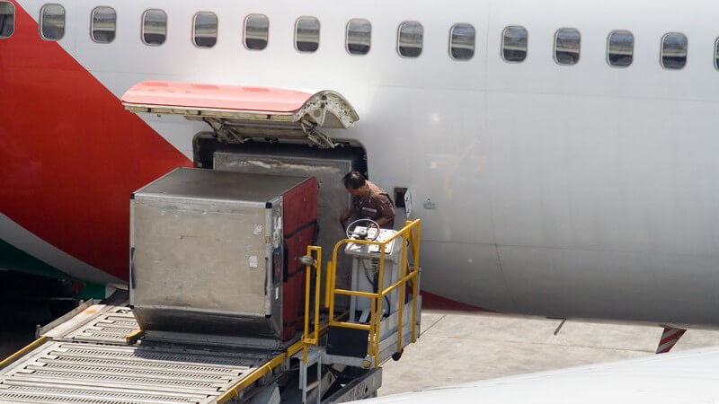 Gepäcklader wird am Flughafen mit Flugzeug verbunden