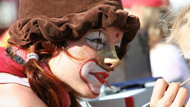 Als Clown geschminkte Frau schminkt Kind, Kinderfest, Straßenfest