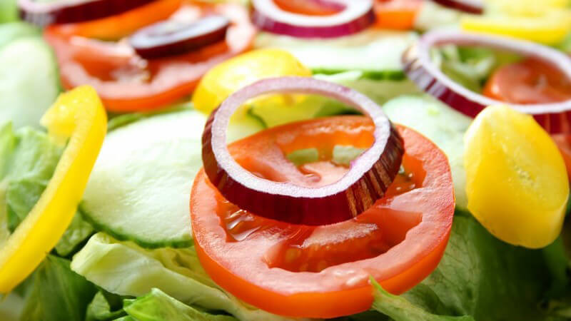 Nahaufnahme frischer Salat mit Tomaten, Gurken, Paprika, Zwiebeln
