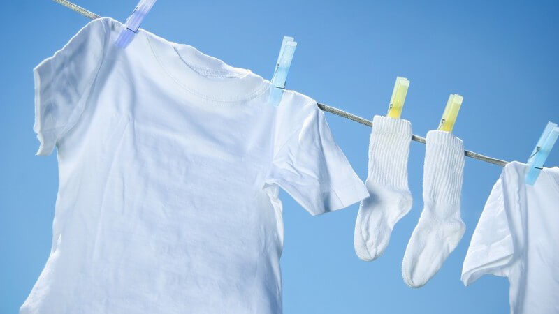 Weiße Wäsche auf der Wäscheleine vor einem hellblauen Himmel