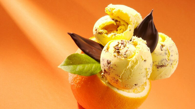Halbe Orange, darauf Eiscreme mit Schokolade