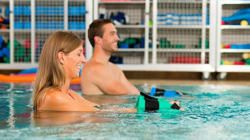 Paar im Schwimmbecken macht Wassergymnastik