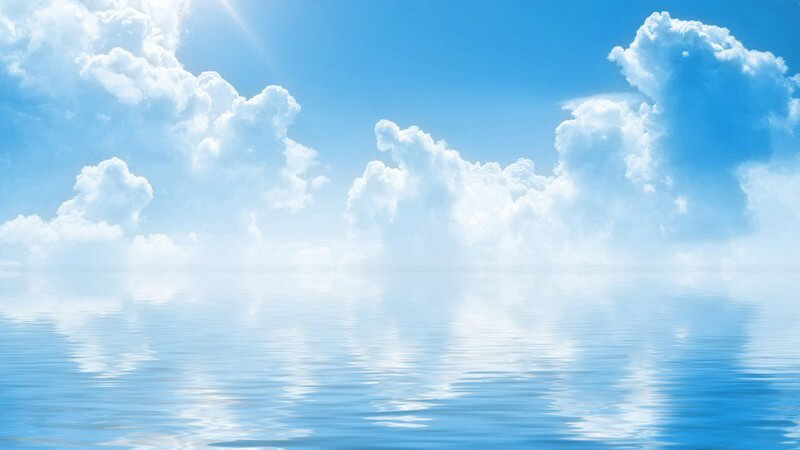 Blauer Himmel, weiße Wolken, Sonnenschein über Wasser