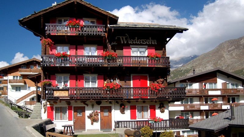 Ferienhaus "Auf Wiedersehen" mit roten Fensterläden in den Bergen