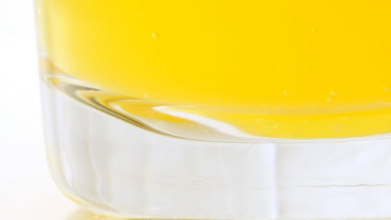 Boden eines Trinkglases mit gelbem Getränk