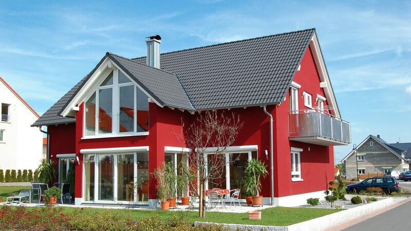 Rotes, modernes Einfamilienhaus mit großen Fenstern