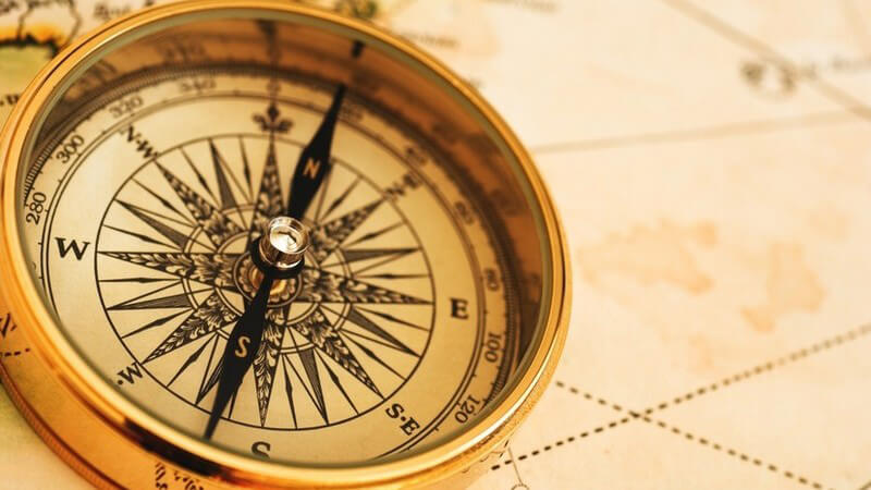 Goldener Kompass auf einer Weltkarte
