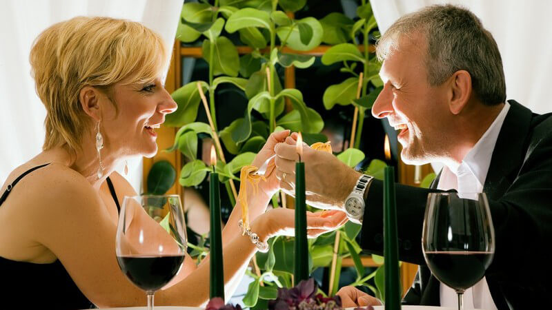 Paar beim Abendessen in Restaurant mit Kerzen, Rotwein