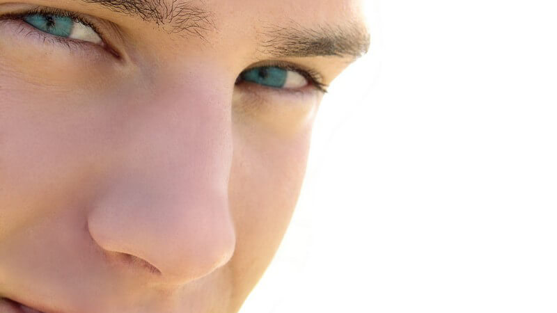 Junger Mann mit strahlend blauen Augen blickt in die Kamera