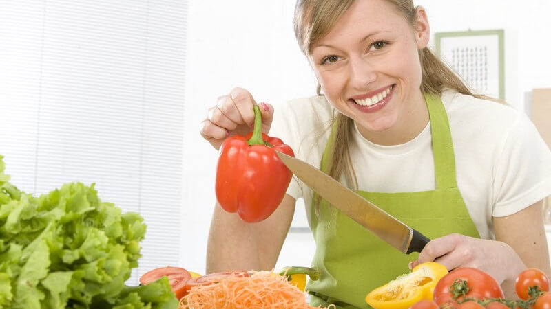 Junge Frau in der Küche macht Salat
