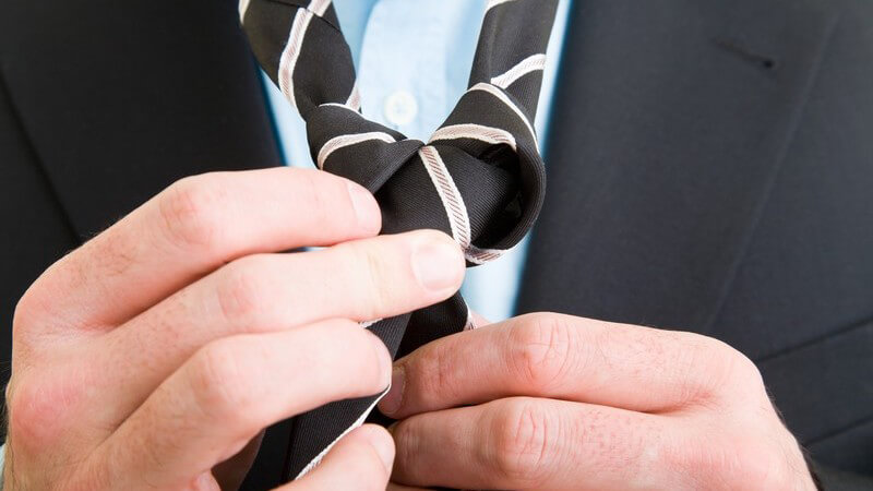 Nahaufnahme Mann bindet Krawattenknoten