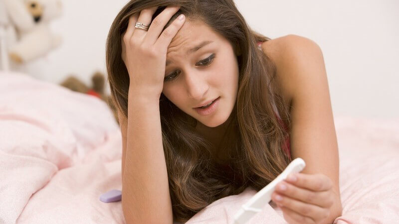 Teenagerschwangerschaft: Junges Mädchen hält Schwangerschaftstest