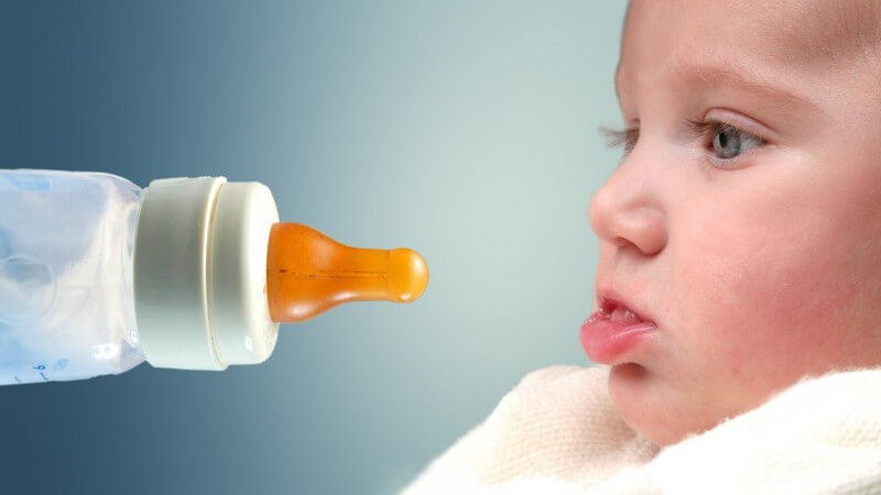 Babyflasche vor Babys Gesicht