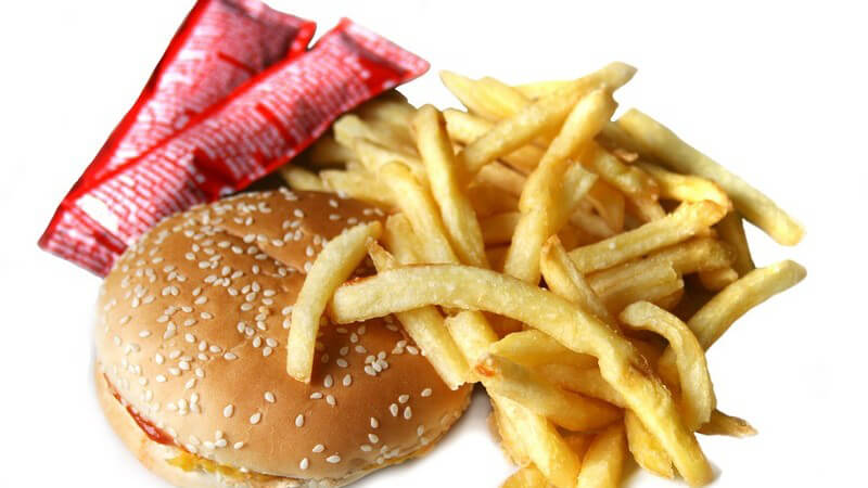 Nahaufnahme Hamburger, Pommes und Ketchup auf weißem Hintergrund