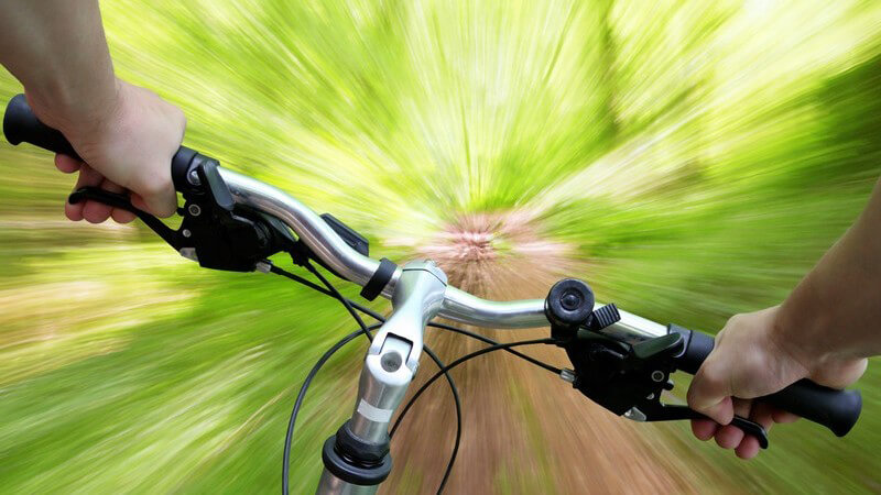 Zoom Optik Mountainbike-Lenker mit Armen bei Tour durch Wald