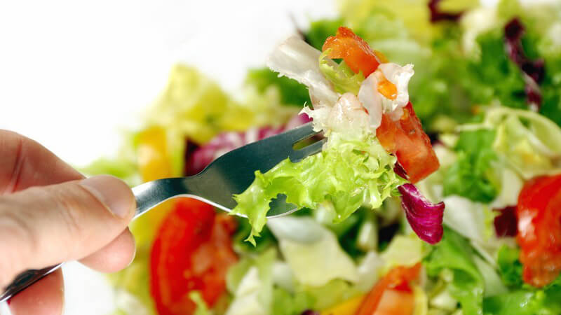Gemischter Salat, Hand steckt eine Gabel hinein
