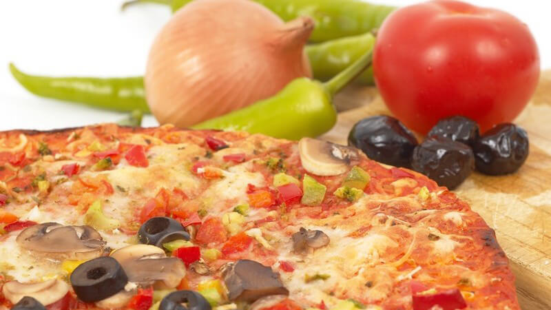 Pizza Italiano oder Diabolo mit Oliven, Zwiebeln, Tomaten, Chilischoten auf Holzbrett vor weißem Hintergrund