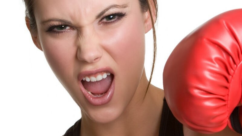 Junge wütende Frau mit roten Boxhandschuhen