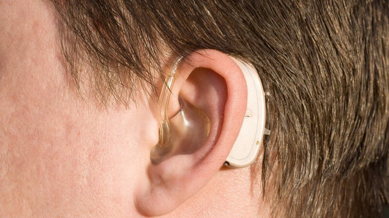 Nahaufnahme linkes Männerohr mit Hörgerät