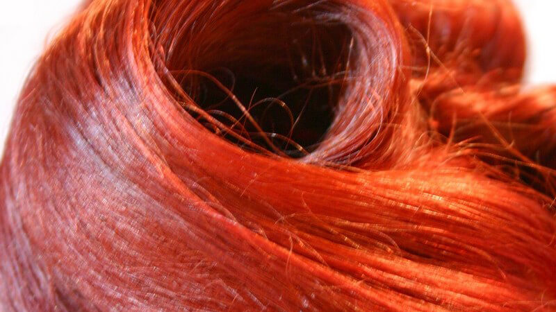 Nahaufnahme rot gefärbte Haare einer Frau auf weißem Hintergrund