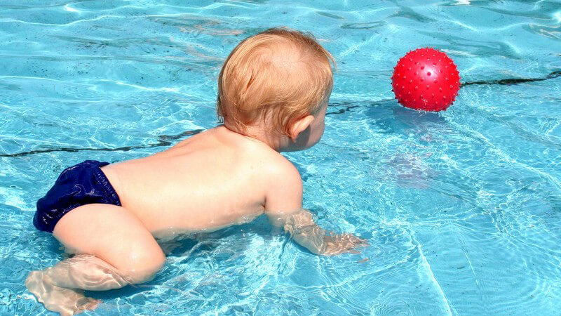 Baby spielt im Pool - Babyschwimmen