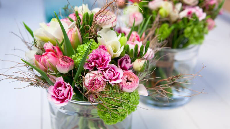 Blumensträuße in Blumenvasen auf dem Tisch, Blumendekoration