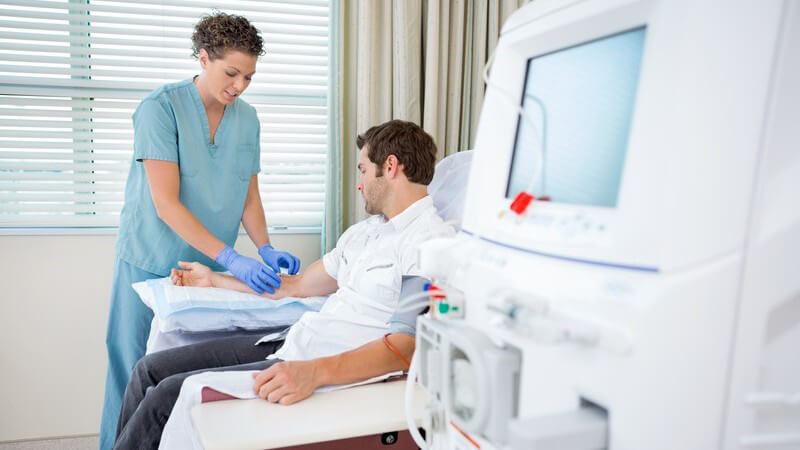 Krankenschwester behandelt einen Patienten vor einer Dialyse-Therapie