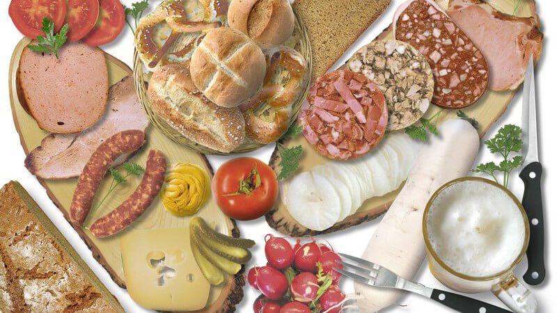 Bild ausgefüllt von verschiedenen Nahrungsmitteln, Brot, Bötchen, Käse, Wurst, Tomaten, Radieschen, Messer und Gabel