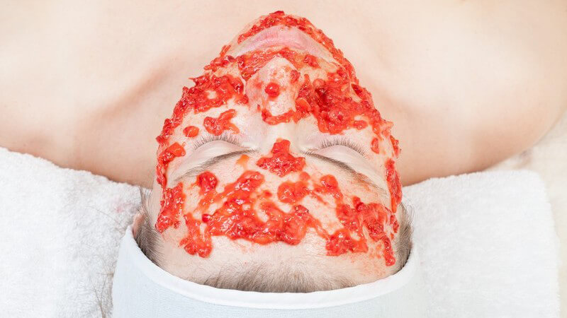 Frau lässt Gesichtsmaske aus roten Beeren einwirken