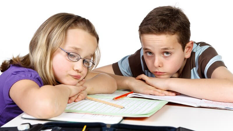 Junge und Mädchen haben keine Lust auf Hausaufgaben oder Lernen