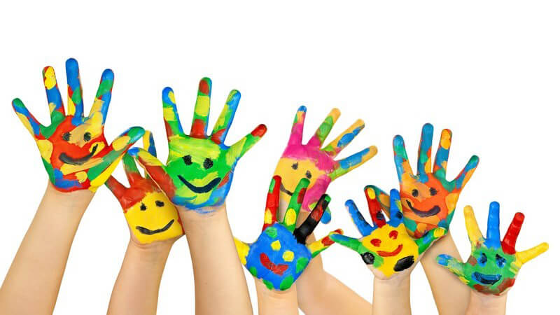 Bunte, bemalte Hände von Kindern mit Smileys auf den Handflächen