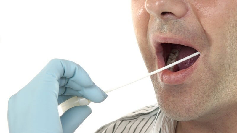 Mann mit offenem Mund bekommt DNA Probe abgenommen