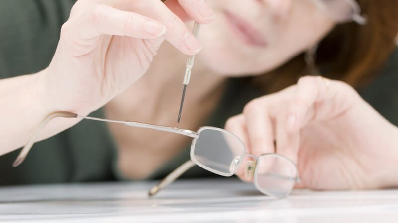Optikerin repariert Brillenbügel