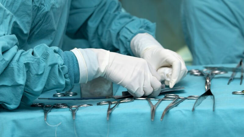 Chirurg bereitet Operationswerkzeuge auf Liege vor