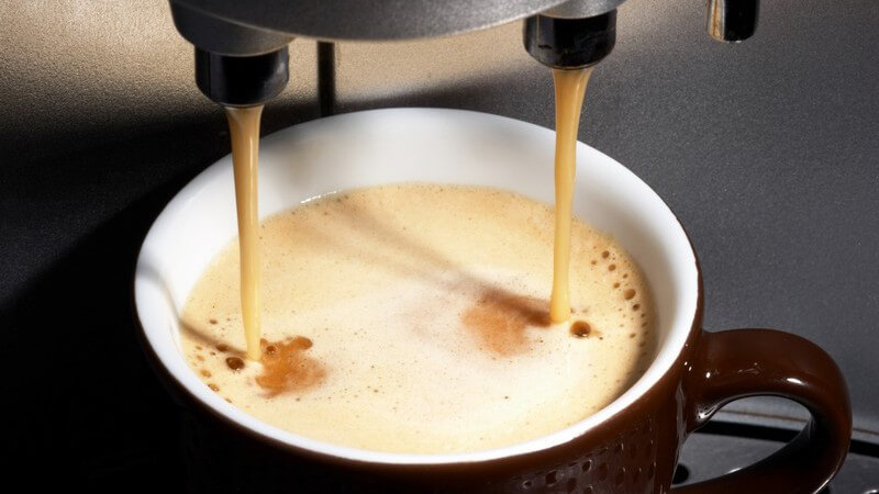 Nahaufnahme Kaffee läuft aus Maschine in Tasse