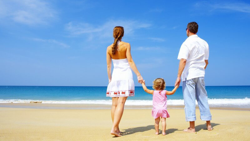 Junge Familie spaziert am Strand