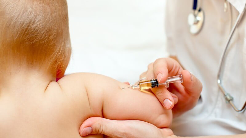 Rückansicht Baby bekommt Spritze vom Kinderarzt, Impfung