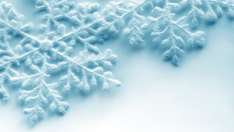 Grafik hellblaue Schneekristalle auf weißem Hintergrund