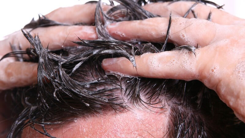 Kopf eines Mannes, er wäscht sich die Haare, weißer Hintergrund