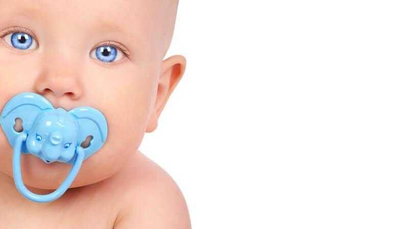Nahaufnahme Baby mit blauen Augen und blauem Schnuller