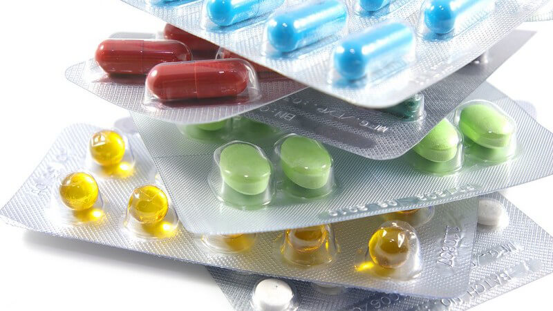 Bunte Tabletten verpackt auf Stapel auf weißem Hintergrund