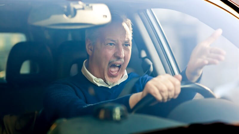 Wütender Mann am Steuer seines Autos schreit